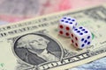 White dice are on a dollar bill of US dollars. The concept of gambling with rates in monetary unit