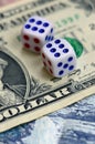 White dice are on a dollar bill of US dollars. The concept of gambling with rates in monetary unit