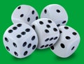 White dices in a pile thrown in a craps game, yatsy or any kind of dice game against a green background Royalty Free Stock Photo