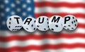 White dices spelling the word TRUMP with American flag waving in the background. USA election concept.