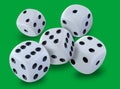 White dices thrown in a craps game, yatsy or any kind of dice game against a green background Royalty Free Stock Photo