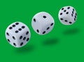 White dices thrown in a craps game, yatsy or any kind of dice game against a green background Royalty Free Stock Photo