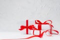 White different size gift boxes with red silk ribbon in white interior, copy space, wedding background. Royalty Free Stock Photo