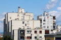 White dilapidated apartment buildings in old part of town with multiple satellite dishes and chimneys in various sizes Royalty Free Stock Photo