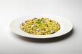 White dinner plate with yellow risotto with saffron, porcini mushrooms and parsley