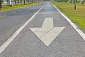 White direction arrow on asphalt road