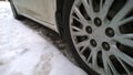 White Dirty Car wheel on road. Messy, Mud, salt, chemicals in winter. Tire. Ecology problem in city. Protection and wash vehicle Royalty Free Stock Photo