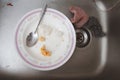 White dirty dish with spoon in sink after eating Royalty Free Stock Photo