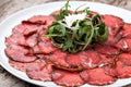 White dish with carpaccio of beef