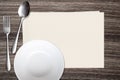 White dish spoon fork and and paper on wood background Royalty Free Stock Photo