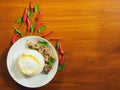 A white dish with steamed rice overlayed with fried eggs and stir-fried with basil with pork Beside, there are chilli and freckles Royalty Free Stock Photo
