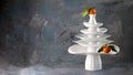 White dishes Pyramid like Christmas tree with mandarins with leaves on top, bunch below on dark Creative concept, dishware, veg, Royalty Free Stock Photo