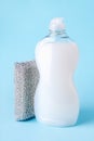 White dishwashing liquid in a transparent plastic bottle and silver foam sponge. Purity and household chemicals. Kitchen detergent