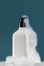 A white dispenser with a cosmetic product in foam on the shelf. Shower gel