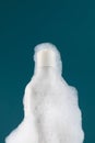 A white dispenser with a cosmetic product in foam on the shelf. Shower gel
