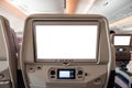 White display screen with joystick on rear seat in airplane