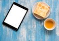 White display Tablet , Toast, Honey on blue wooden floor.