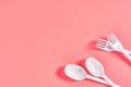 White disposable spoons and forks on pink background Royalty Free Stock Photo