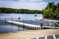 A white dock bridge with a lake and green trees