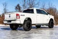 White Dodge Ram 2500 truck parked on a concrete surface in a natural setting.