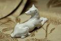 White dog statue on a gold antique flower pattern fabric Royalty Free Stock Photo