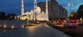 the white domed mosque at night and decorated with various lights