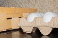 White domestic chicken eggs in a lattice next to a wicker basket Royalty Free Stock Photo