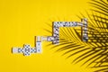 White dominoes with colorful dots on a yellow background. Board game.