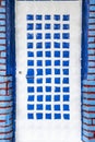 White door with blue square decorations in an ancient region, close up