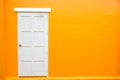 White door classic vintage on the color orange wall Royalty Free Stock Photo