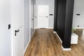 A white door with a ventilation undercut with a matte black handle and a black line in the middle in a modern house with vinyl pan Royalty Free Stock Photo