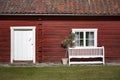 White door and window on a red, old wooden house Royalty Free Stock Photo