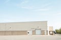 white doors and receiving bay doors on large one story beige building 207 p 17 h Royalty Free Stock Photo