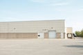 white doors and receiving bay doors on large one story beige building 205 p 17 Royalty Free Stock Photo