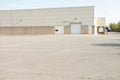 white doors and receiving bay doors on large one story beige building 206 p 17 Royalty Free Stock Photo