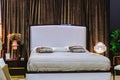 White double bed in the bedroom. Brown soft curtains behind the head of the bed Royalty Free Stock Photo