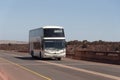 A white double decker bus travelling on highway towards Saldanha, West Coast, S. Africa.