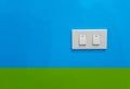 White electric switches against blue and green background Royalty Free Stock Photo