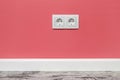 White double outlet on pink wall