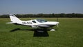 White double-seat propeller-driven PS-28 Cruiser airplane takes off on grass landing strip in co