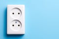 White double socket isolated on blue background. Electric lighting Royalty Free Stock Photo