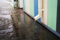 White drainpipe with flooded pavement. Rain water flowing from drain pipe closeup