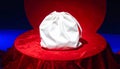 White drawstring bag on red velvet cloth on a red circular platform and blue background Royalty Free Stock Photo
