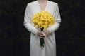 White dress woman holding yellow lily flower bouquet Royalty Free Stock Photo