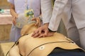 A white dressing nurse perform chest compression with another as