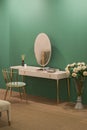 White dressing table with wicker elements, a room with a green wall and golden brass furniture, luxury mirror, female boudoir