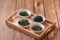 The white drinking bowls of assortment of dry tea in order on wooden background Royalty Free Stock Photo