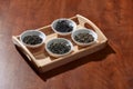 The white drinking bowls of assortment of dry tea in order on wooden background Royalty Free Stock Photo