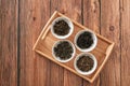 The white drinking bowls of assortment of dry tea in order on wooden background Royalty Free Stock Photo