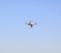 White drone against the blue evening sky. Multicopter flight.